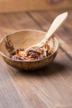 Wooden spice mix in a bowl with a wooden spoon. On wood surface.の写真素材