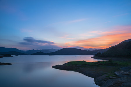 The evening lake reflected the mountains and the sky on both sides;の写真素材