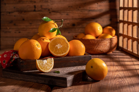 Under the dim light, the oranges on the plate are on the wooden table, like oil paintingsの写真素材