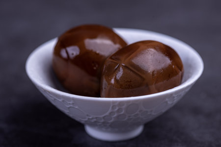 Chinese tea eggs, cut or whole marinated eggs in dark backgroundの写真素材