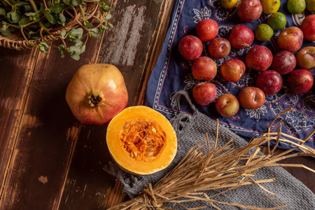 Pumpkins and many other colors and varieties of fruits and vegetables are on the wood grain tableの写真素材