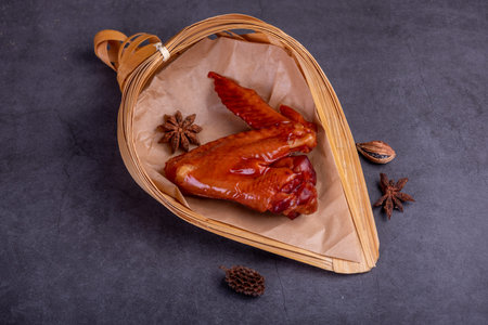 Marinated chicken wings on a plate against a dark background