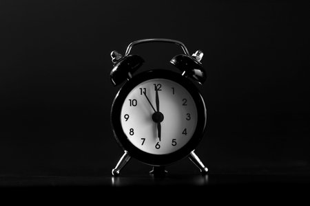 close-up. Black old style alarm clock isolated on black background.