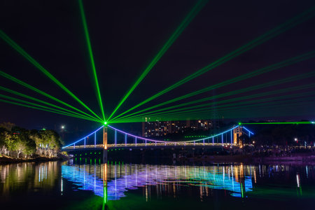 At night, the stream reflects the colorful lights on the bridge