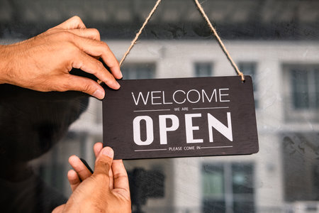 Asians with sign open and closed in restaurant for lockdown ideas unlock freedom tourist travel for lifestyle customer sign open and closed welcome new normol during Coronavirus disease covid-19 unlock lockdownの写真素材