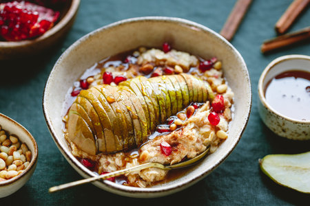 Overnight oatmeal with cinnamon, honey, pear, pomegranate seeds and pine nuts. Healthy vegan breakfast.の写真素材