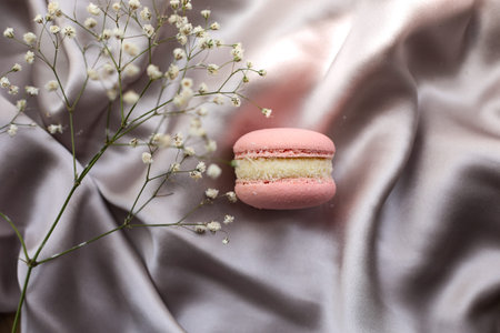pink french macaroons or macarons cookies and a white flowers on a cloth background. Natural fruit and berry flavors, creamy stuffing for valentines mother day easter with love foodの写真素材