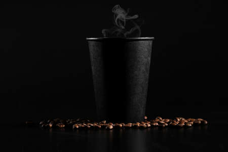 fragrant coffee on the table A black glass with hot coffee on a dark background. scattered coffee beans.の写真素材