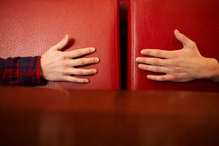 Male and female hands are reach to each other on a red background. concept of care, support, love. toningの写真素材