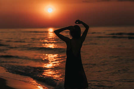 beautiful morning sunrise, silhouette of the girl at sunset.の写真素材