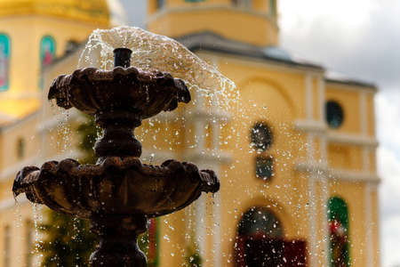 Close-up of an old stone fountain with dripping water and blurred background.の写真素材