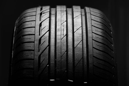 Studio shot of brand new car tire isolated on black background. close up.
