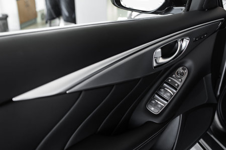 details of the car interior, black leather interior. windows control panel