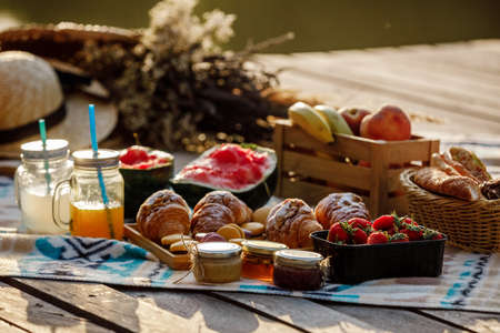 Picnic at the park. Fresh fruits, ice cold sparkling drinks and croissants on a hot summer day. Picnic lunch. selective focus.の写真素材