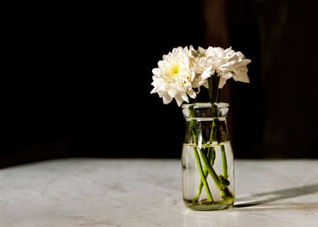 White Flower bouquet in a Vase on wooden tableの写真素材