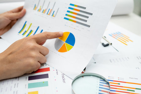 Asian accountant working and analyzing financial reports project accounting with chart graph and...