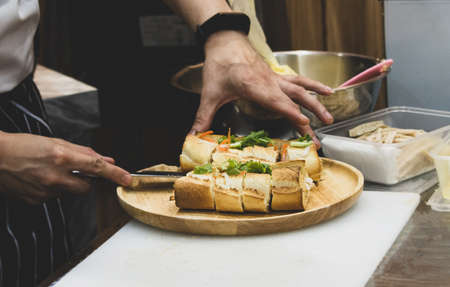 chef prepares sandwich in the kitchen, Delicious sandwich with veggies and meatの写真素材