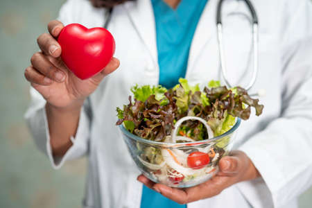 Nutritionist doctor holding various healthy fresh vegetables for patient.の写真素材