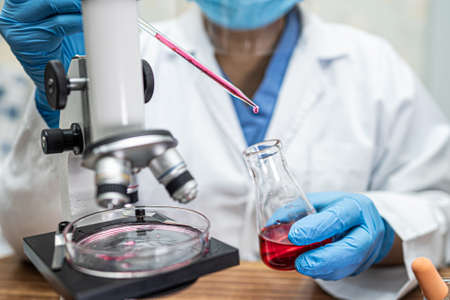 Scientist holding and analysis tube of micro biological sample outbreak Coronavirus or Covid-19 infectious in laboratory for doctor in the world.の写真素材
