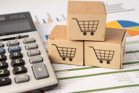 Shopping cart on box with calculator on graph background. Banking Account, Investment Analytic...