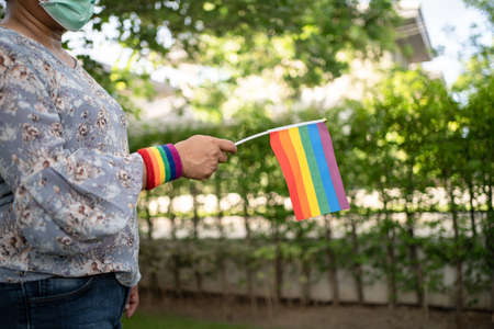 Asian lady holding rainbow color flag, symbol of LGBT pride month celebrate annual in June social of gay, lesbian, bisexual, transgender, human rights.の写真素材