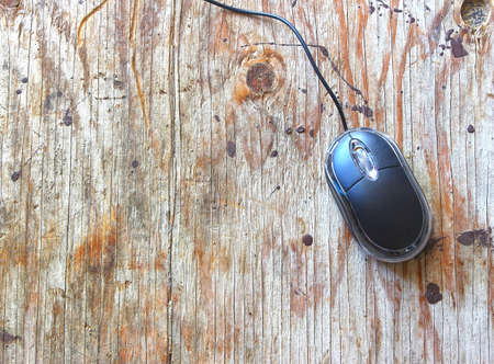 Black wired computer mouse on wood tableの写真素材