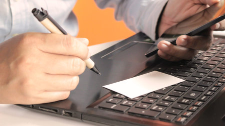 Hands using laptop and smartphone check business cards for calling online shopping with daytime soft...