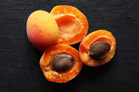 Photography of apricots open and cut in halves and apricots kernels for food backgroundの写真素材