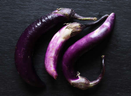 Three fresh japaneese eggplants on slate for food illustrationsの写真素材
