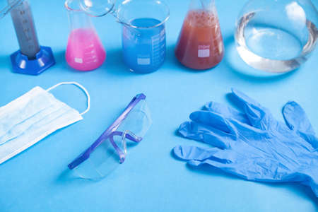 Science glassware with colored liquid gloves and glasses.の写真素材