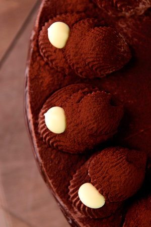 Chocolate cake above with fresh cocoa on wooden table