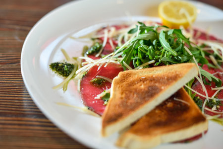 Black angus beef carpaccio with parmesan cheese on a plate