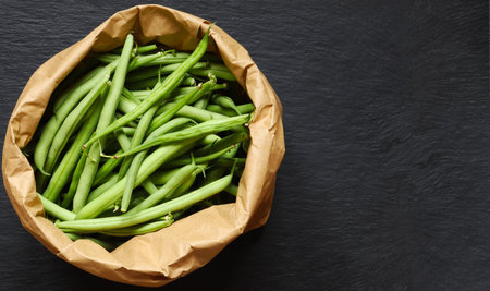 Photography of green beans in a brown paper bag on slate background for menu, label or sign /The...
