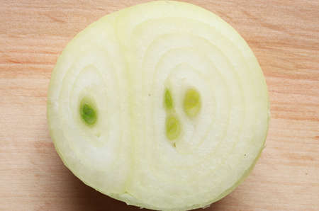 Photography of a half peeled and cut onion on wooden board for food backgroundの写真素材
