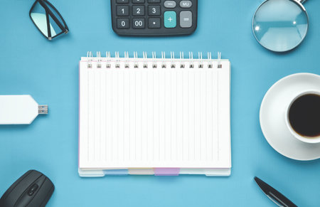 Notepad with a business objects on the blue background.