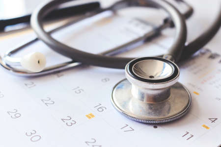 annual checkup concept. stethoscope on the calendar with soft-focus and over light in the backgroundの写真素材
