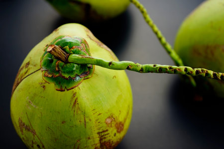 Group, pile of fresh green raw coconuts from plantation flat lay on black texture abstract...