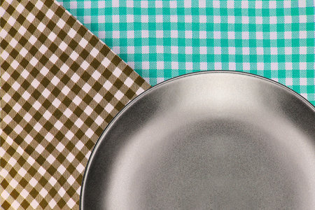 Top view plate on checkered tablecloth pattern background