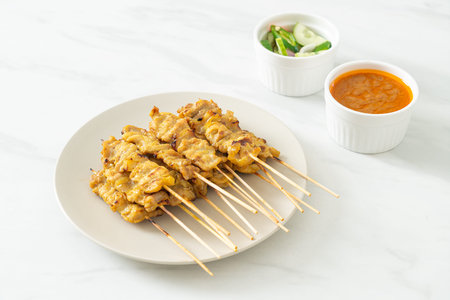 Pork satay with peanut sauce pickles which are cucumber slices and onions in vinegarの写真素材