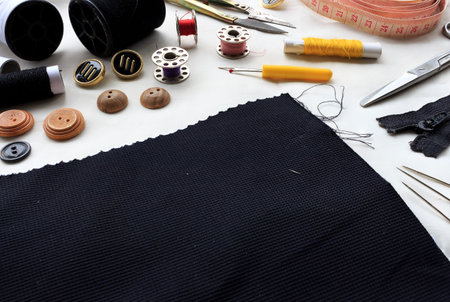 sewing tools on white fabric background. over light, retron and high contrast
