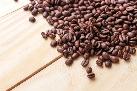 coffee beans on wood background, over light