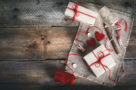 Vintage gift boxes with blank gift tag on old wooden background.