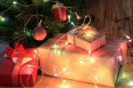 light celebration on christmas tree with gift box in living room