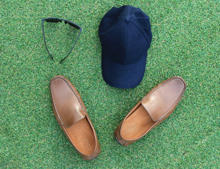sets of hat,sunglasses and shoes on green grass