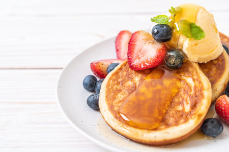 pancake with blueberries, strawberries, honey and vanilla ice-cream