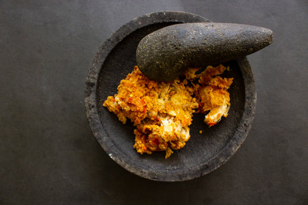 ayam geprek or chicken crush or chicken smashed is indonesian food made from made fried chicken pounded with chilli and garlic flavour and served with vegetables and riceの素材