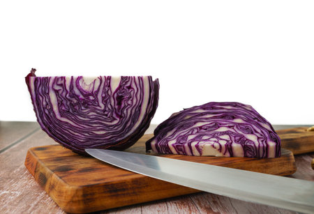 close-up of a red cabbage or purple cabbage cut with a knife on a wooden boardの素材