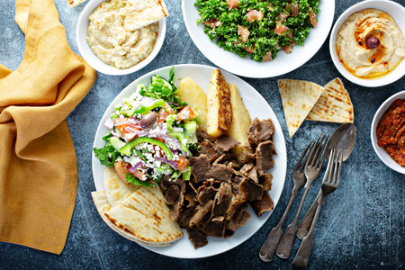 Mediterranean food on the table, gyro platter, pita and dips and tabboulehの素材