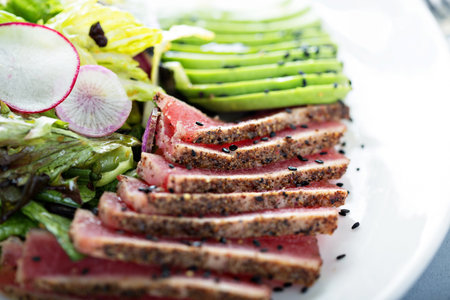 Tuna steak salad with sliced avocado and lettuce close upの素材