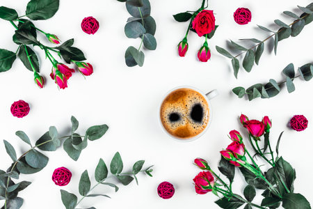 Isolated white background with a Cup of coffee surrounded by flowers. Flat lay, top view.の素材